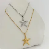 Collar dorado con cadena de eslabones retorcidos y dije de estrella de mar con diseño de espiral en el centro.