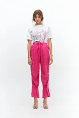 Pantalón fucsia de lino, con cintura elástica ajustable con lazo, bolsillos laterales y presillas en las piernas.