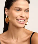 Aros colgantes grandes de metal dorado con forma de hoja ondulada.