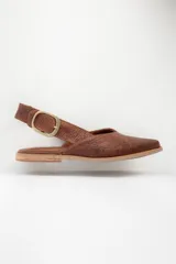 Zapato chata de cuero color marrón con textura tejida y hebilla dorada.