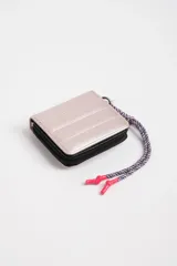 Billetera pequeña rosa con diseño capitoneado y cierre de cremallera. Incluye llavero de cordón trenzado con terminales plásticas rosas.