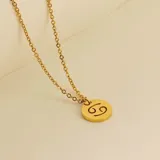 Collar dorado con dije redondo con el signo de Aries grabado.