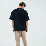 Remera negra de algodón con cuello redondo y mangas cortas. Estampado pequeño en el pecho con texto y logo de la marca KicksLab.