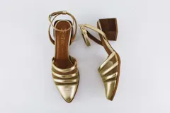 Sandalias doradas de cuero sintético con tiras de tela transparente y tacón de madera.