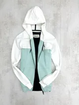 Campera con capucha blanca y turquesa con cierre frontal y bolsillos tipo canguro.