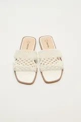 Sandalias bajas color blanco con tiras anchas de tejido trenzado.