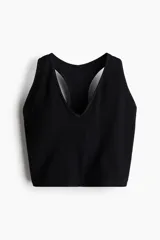 Top deportivo negro acanalado, confeccionado en tejido funcional DryMove™ que ayuda a absorber el sudor. Tiene breteles anchos, espalda nadadora y copas forradas con relleno extraíble.