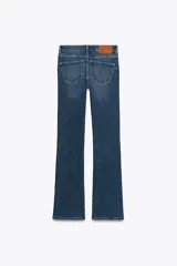 Pantalón de jean azul oscuro, de tiro bajo, corte slim fit y bootcut. Con cinco bolsillos y cierre frontal con cremallera y botón.
