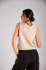 Chaleco tejido celeste con terminaciones en punto festón negro.