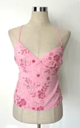 Top rosado con breteles finos y bordado de flores. Espalda regulable.