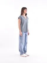 Blusa blanca de corte holgado, con cuello en V y mangas cortas.