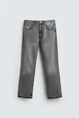 Pantalón de jean gris de tiro medio, corte ajustado en la parte superior y acampanado desde la rodilla, con cinco bolsillos y terminación desflecada en el ruedo. Cierre frontal con cremallera y botón.