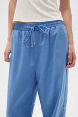 Pantalón celeste de lino, corte recto, con cintura elástica ajustable con cordón y bolsillos laterales.