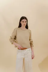 Blusa color beige de lino 100% con mangas balloon y detalle de tablón en el hombro. Tiene mangas largas con detalle de 2 pespuntes elásticos en contratono, el recurso del elástico es ideal para remangarse la manga generar más volumen. Calce recto, largo por arriba de la cadera.