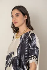 Blusa italiana color natural con estampado de hojas en tonos azules. De calce holgado y talle único.