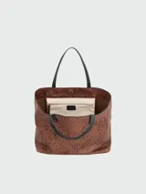 Bolso de shopping de cuero marrón con estampado de leopardo y asas negras en contraste.