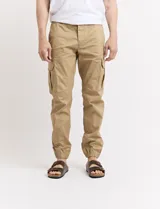 Pantalón cargo verde con bolsillos laterales, corte slim fit y tobillos elastizados.
