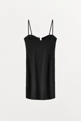Vestido corto negro confeccionado en hilatura con poliamida. Presenta escote corazón con pieza metálica forrada en el pecho y tirantes finos ajustables.