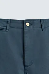 Pantalón relaxed fit color azul petróleo confeccionado en tejido de algodón. Cuenta con bolsillos frontales, bolsillo cerillero y bolsillos traseros de doble vivo. Presenta lavado con efecto rotos. Cierre frontal con cremallera y botón.