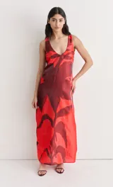 Vestido largo de seda con estampado floral abstracto en blanco sobre fondo negro, escote redondo y corte recto.