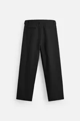 Pantalón negro de corte ancho con cinturón de tela con hebilla metálica y pliegues frontales.