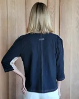 Camisa color beige claro con cuello con volados y mangas 3/4 abullonadas.