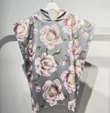 Poncho de toalla gris con capucha y estampado de flores rosas.