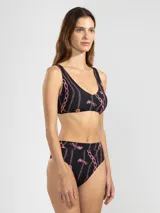 Bikini negro con estampado de cadenas y tigres en color rosa. El corpiño es de corte deportivo y la bombacha es de tiro alto.