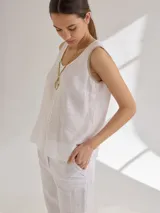 Musculosa blanca de lino con corte holgado y detalles de pespuntes en contraste.