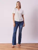 Remera blanca de poliéster, rayón y elastano, con cuello a la base y escote en V. Manga corta amplia bordada. Marca Cable & Gauge.