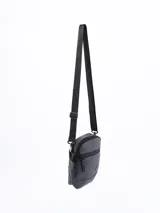 Morral bandolera negro con cierre superior y bolsillo frontal con cierre.