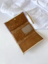 Billetera de cuero color crema, lila y beige con cierre de broche y monedero externo.
