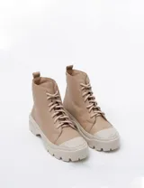 Borcego acordonado color beige de cuero, con puntera reforzada y suela track.