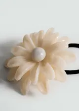 Coletero con elástico negro y aplique de flor color crema.