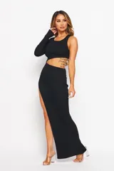 Vestido largo negro de punto acanalado, con un hombro descubierto, manga larga en un brazo, abertura lateral alta y corte ajustado.