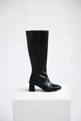 Botas bucaneras de caña alta confeccionadas en cuero con textura croco color marrón, con cierre lateral y taco cuadrado. Hechas en Uruguay.