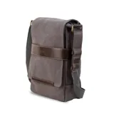 Matera de tela canvas color gris oscuro, combinada con detalles en símil cuero marrón. Cuenta con tapa y broches magnéticos, bolsillo tipo guantera bajo la tapa, división interna desmontable con velcro para usar como morral, bolsillo trasero con broche magnético y correa larga regulable.