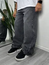 Pantalón baggy gris oscuro de denim con aberturas laterales con terminaciones desflecadas.