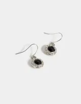 Par de aros colgantes plateados con forma circular, con centro de piedra negra y borde de strass.