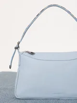 Cartera tipo baguette color celeste, confeccionada en cuero vacuno flor. Incluye correa regulable en combinación de cuero y pelo vacuno, con hebillas metálicas personalizadas.