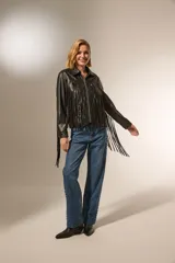 Chaqueta de cuero sintético negra con flecos en la espalda y mangas, cuello camisero, cierre frontal con cremallera y bolsillos laterales.