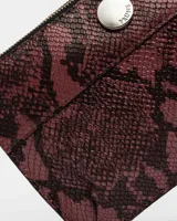 Sobre de cuero con estampado de serpiente metalizado en tonos burdeos y marrón.