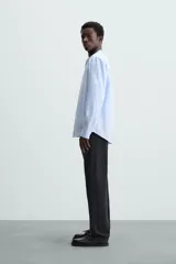 Camisa negra de lino y algodón, corte relaxed fit, cuello mao, manga larga con puños abotonados y cierre frontal con botones.