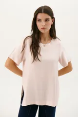 Blusa manga corta color rojo con cortes laterales y abertura abotonada en la espalda. Los pespuntes a contratono resaltan el escote y los cortes.