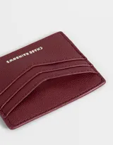 Tarjetero de cuerina color borgoña con múltiples ranuras para tarjetas y logo de la marca en relieve.