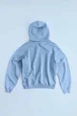 Sudadera celeste con capucha y manga larga, confeccionada en algodón 100% con efecto lavado.