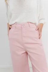 Pantalón de tiro alto, corte palazzo amplio y fluido, color celeste claro. Presenta bolsillos delanteros y traseros tipo jean, con logo metálico Peach en la parte posterior.