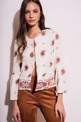 Blusa blanca con estampado de cachemir en color marrón y bordado floral en el ruedo y mangas acampanadas.