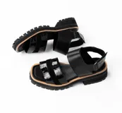 Sandalias negras de cuero con plataforma y tiras con textura de cocodrilo.