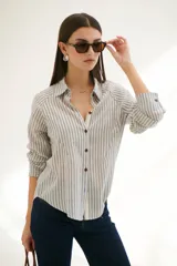 Camisa a rayas verticales color beige y blanco, con cuello clásico, botones marrones y mangas largas.